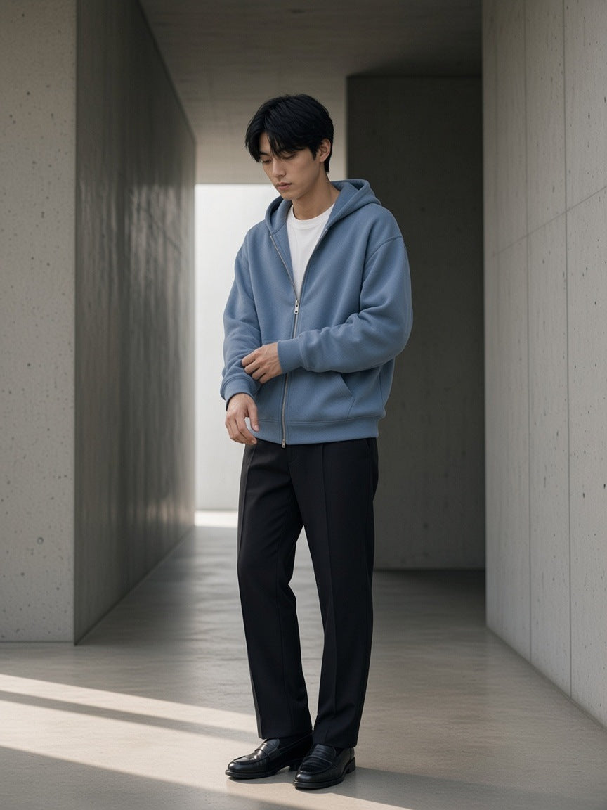 Man in the Drop Shoulder Full Zip Hoodie in Haze Blue in a stone gallery in the morning