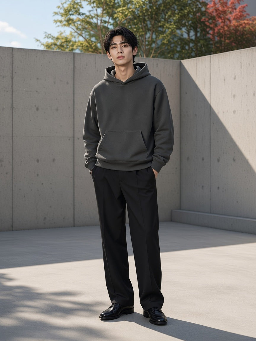 Man in the Drop Shoulder Hoodie in Dark Gray in a concrete courtyard in the morning in Tokyo