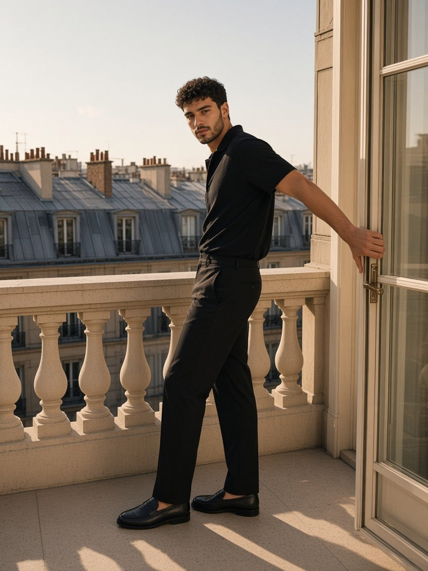 Man in the Drop Shoulder Short-Sleeve Polo in Black on a hotel terrace in Paris in the morning
