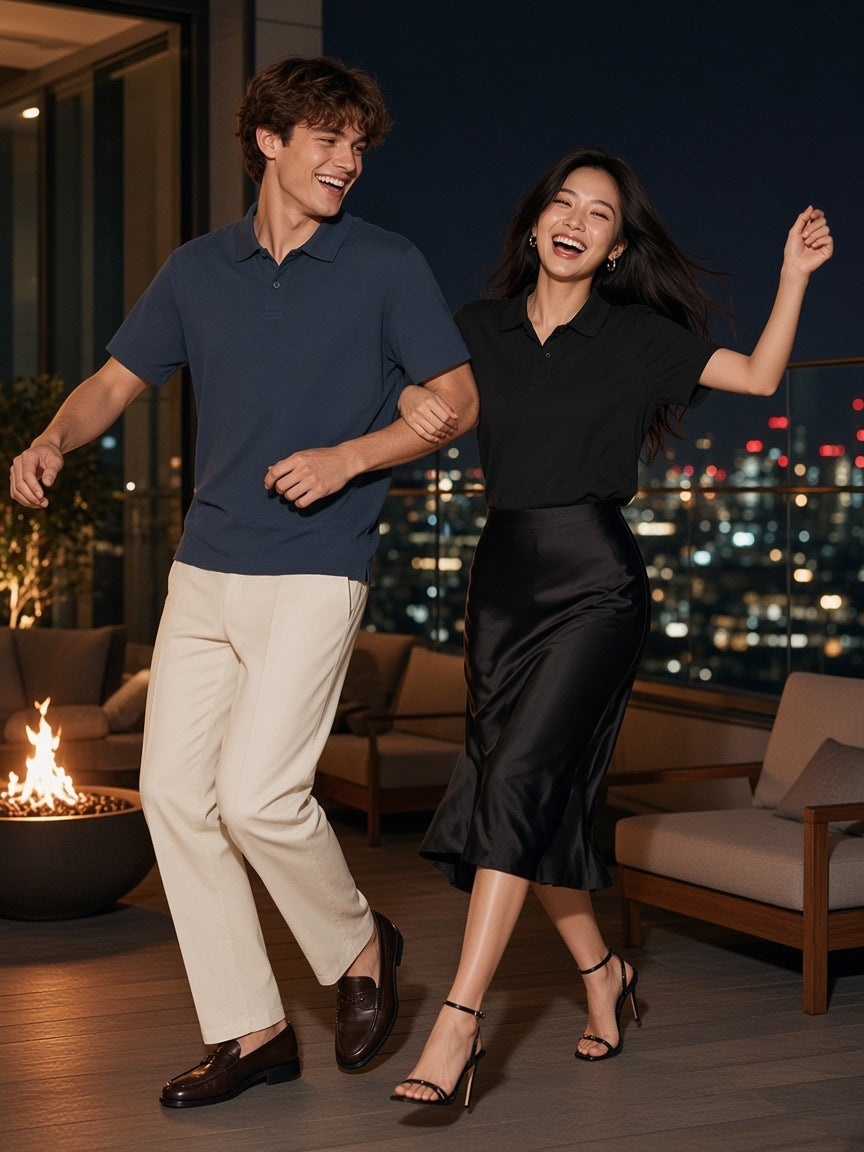 Two people in the Marcel Afters Drop Shoulder Short-Sleeve Polo in Navy Blue and Black dancing on a Tokyo rooftop at night