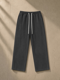 Vintage Wash Fleece Sweatpants in Black, laid flat on pale limestone, front view