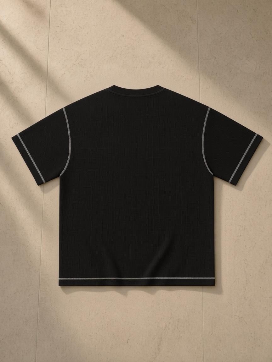 Sunfade Waffle Boxy T-Shirt in Black, laid flat on pale limestone, back.