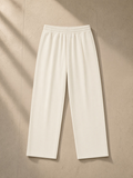 Striped Pleated Pants in White, laid flat on pale limestone