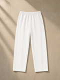 Tapered straight hem sweatpants in White on a wooden hanger in a Tribeca loft at night