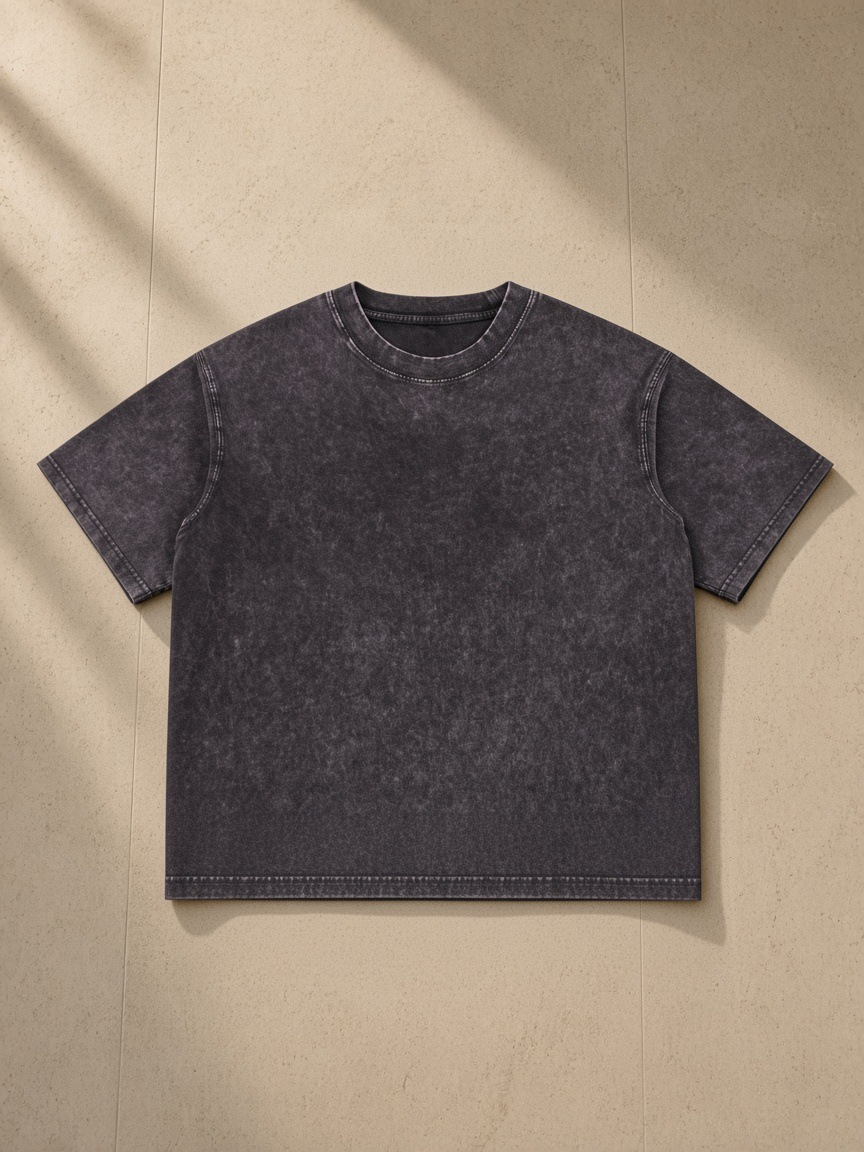 Unisex mineral wash boxy cotton t-shirt in Dark Gray, laid flat on pale limestone