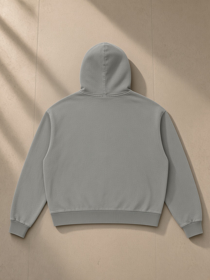 Mineral Wash Boxy Hoodie in Light Gray, laid flat on pale limestone, back view