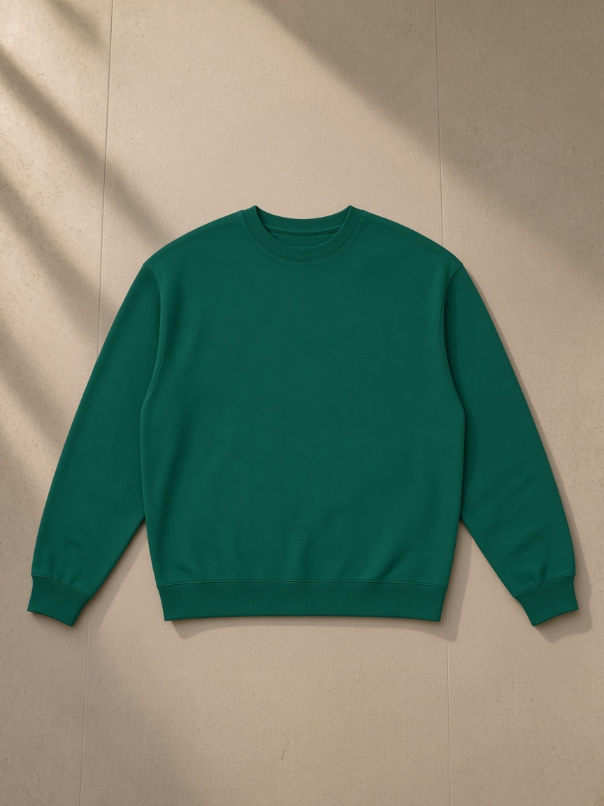 Loose Crewneck Sweatshirt in Dark Green, laid flat on pale limestone, front.