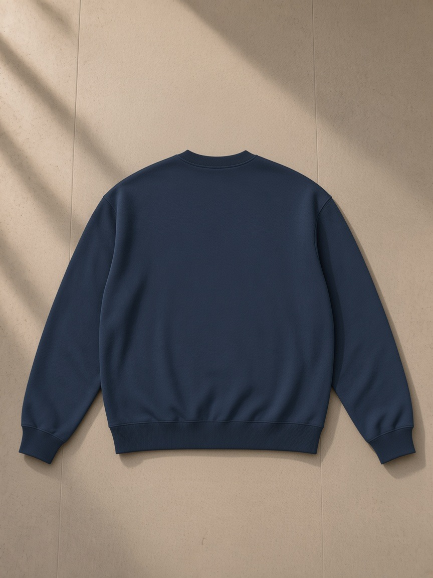 Oversized drop shoulder crewneck sweatshirt in Navy Blue, laid flat on pale limestone, back view