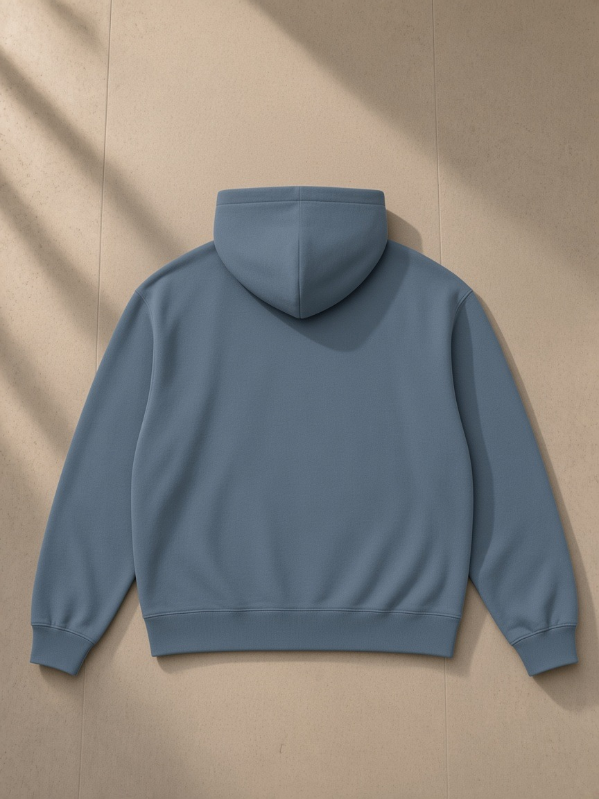 Heavyweight pullover hoodie in Gray Blue, laid flat on pale limestone, back view