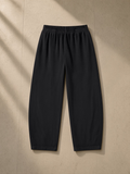 Vintage washed barrel leg sweatpants in Black, laid flat on pale limestone