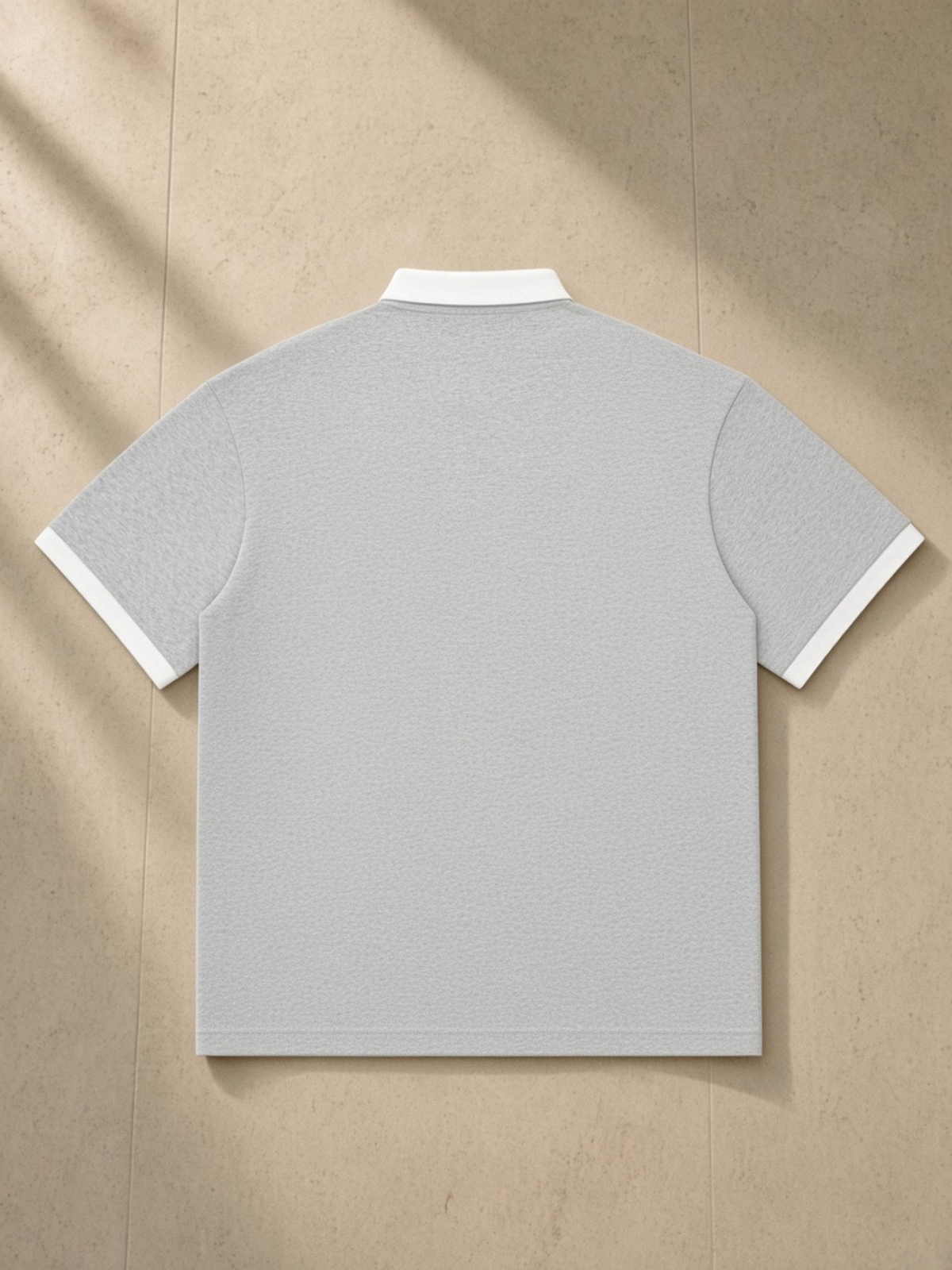 Essential Contrast Polo Shirt in Flower Gray, laid flat on pale limestone, back.