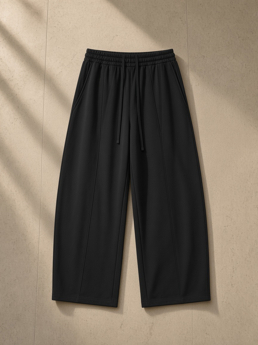 Heavyweight Wide Leg Panel Sweatpants in Black, laid flat on pale limestone