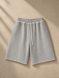 Heavyweight Raw Edge Shorts in Flower Gray and Apricot, laid flat on pale limestone