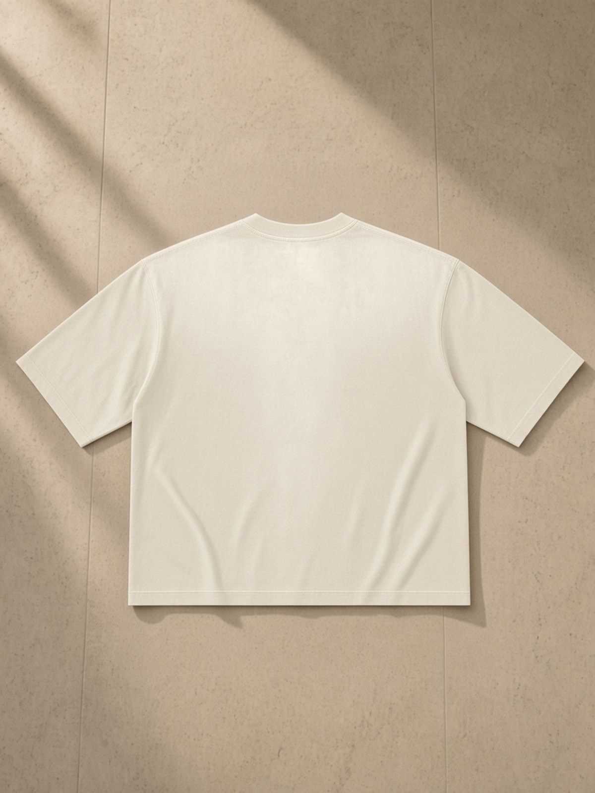 Vintage Wash Sunfade Boxy T-Shirt in Apricot, laid flat on pale limestone, back view