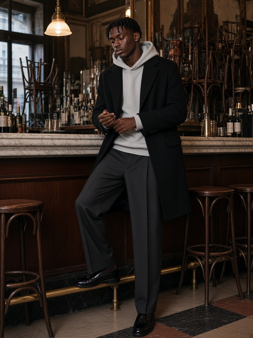 Man in the Essential Boxy Darted Sleeve Hoodie in Flower Gray standing on the terrace of a stone lodge in Wyoming at night