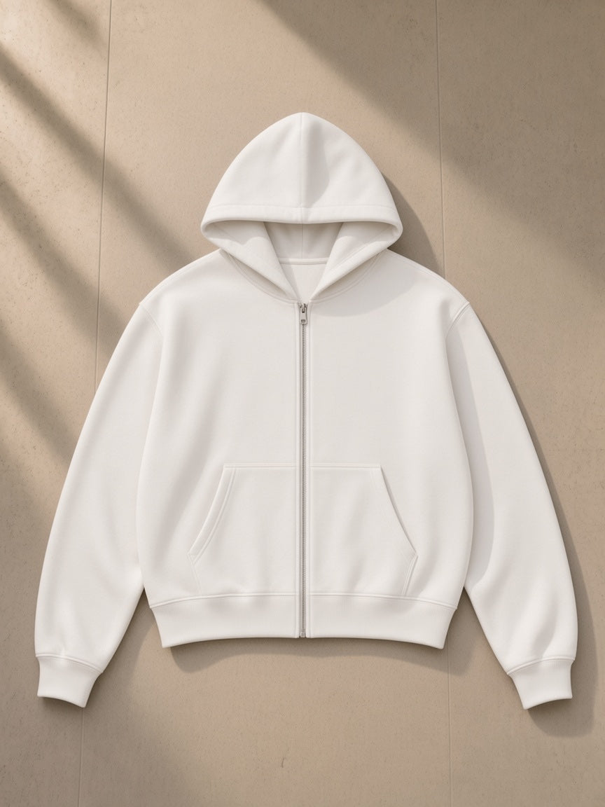 Essential cropped zip-up hoodie in White, laid flat on pale limestone, front view