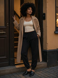 Woman in the Essential Drawstring Jogged Sweatpants in Black in an apartment doorway in Stockholm at night