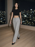 Woman in the Essential Drawstring Straight-Leg Sweatpants in Flower Gray walking through a hotel suite above Tokyo at night