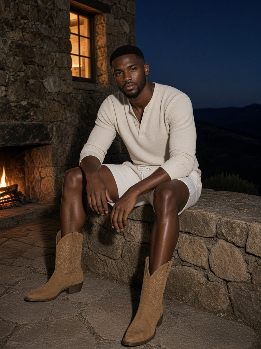 Man in the Essential Fleece Drawstring Sweatshorts in White by a stone fireplace at a ranch lodge in Wyoming at dusk