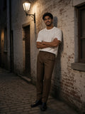 Man in the Essential Half Sleeve Ribbed T-Shirt in White in a cobbled alley in Antwerp at night