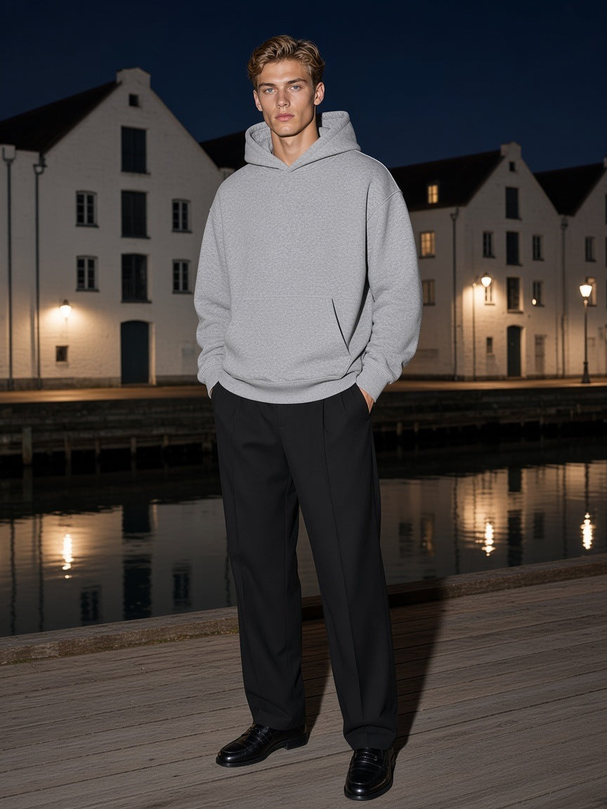 Man in the Marcel Afters Essential Heavyweight Boxy Fleece Hoodie in Flower Gray on a harbour quay in Copenhagen at night