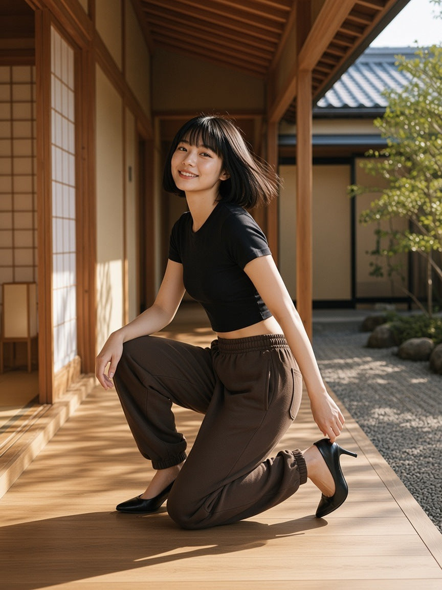 Woman in Essential Heavyweight Cotton Sweatpants in Coffee with heels in a ryokan hotel corridor in Kyoto in the morning