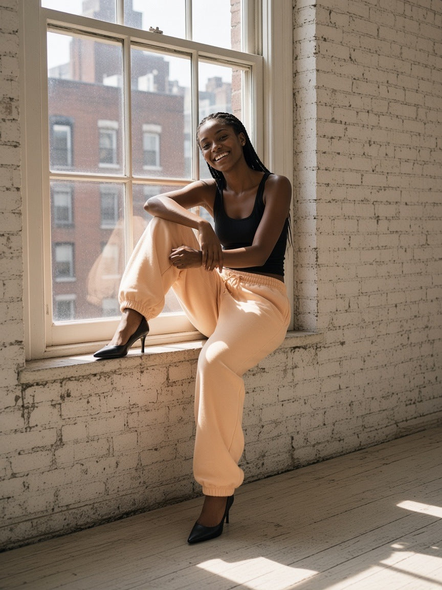 Woman in the Essential Heavyweight Cotton Sweatpants in Apricot in a Tribeca loft in New York in the morning