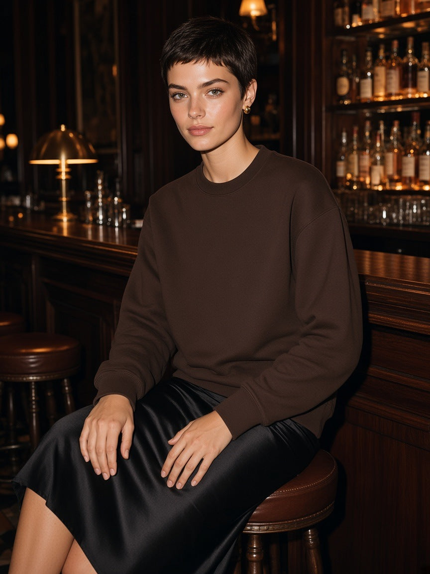 Woman in the Essential Heavyweight Cotton Sweatshirt in Coffee seated at a hotel bar on the Upper East Side, New York at night