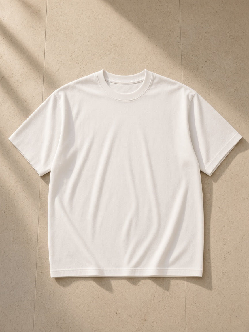 Women's Essential Heavyweight Cotton T-Shirt in White, laid flat on pale limestone