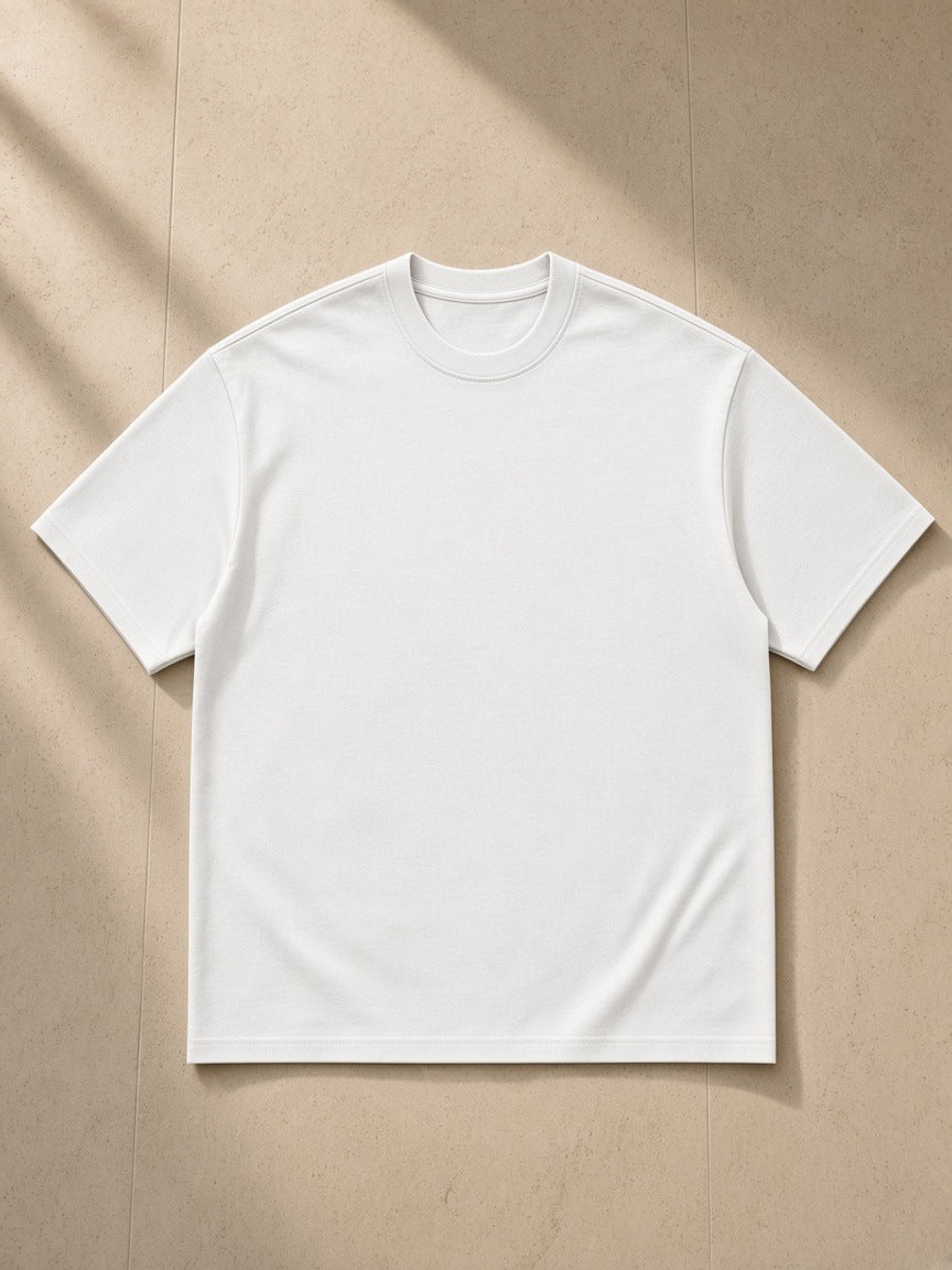 Essential Heavyweight Cotton T-Shirt in White, laid flat on pale limestone
