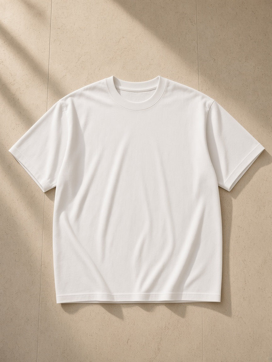 Women's Essential Heavyweight Cotton T-Shirt in White, laid flat on pale limestone