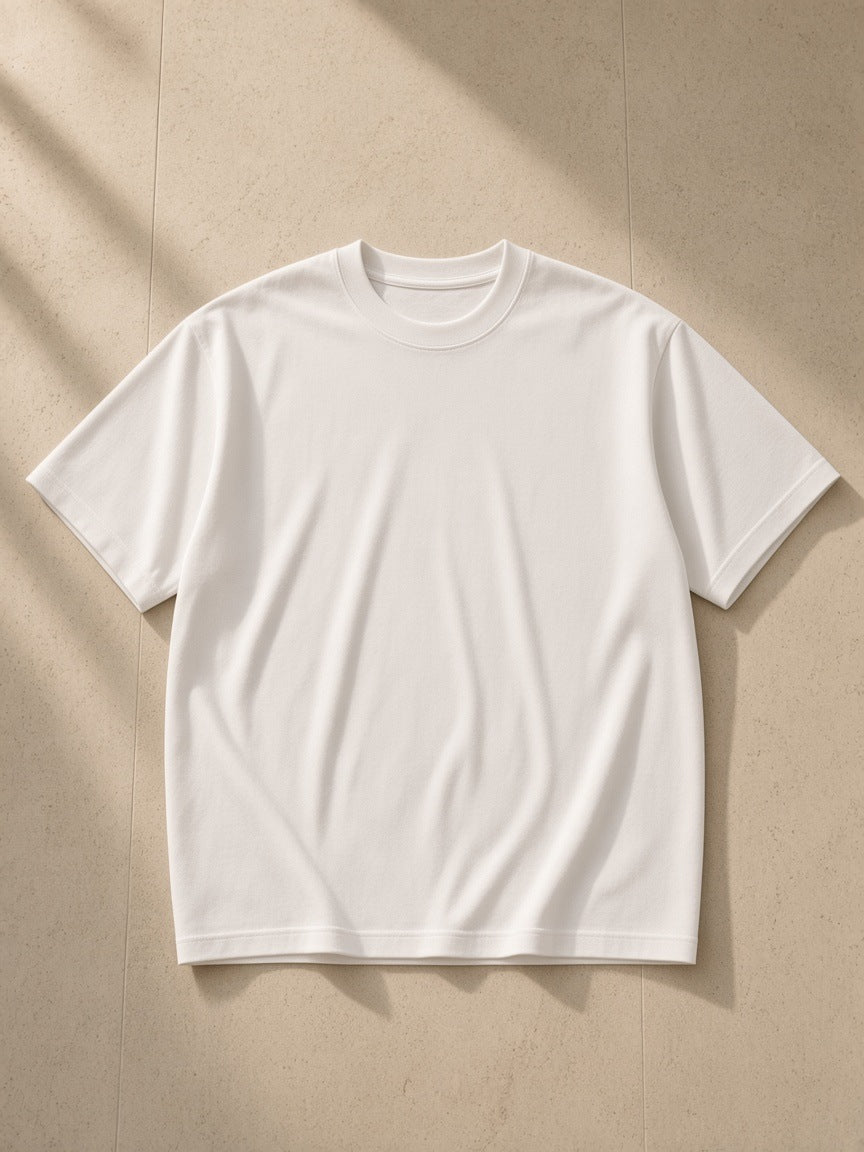 Men's Essential Heavyweight Cotton T-Shirt in White, laid flat on pale limestone