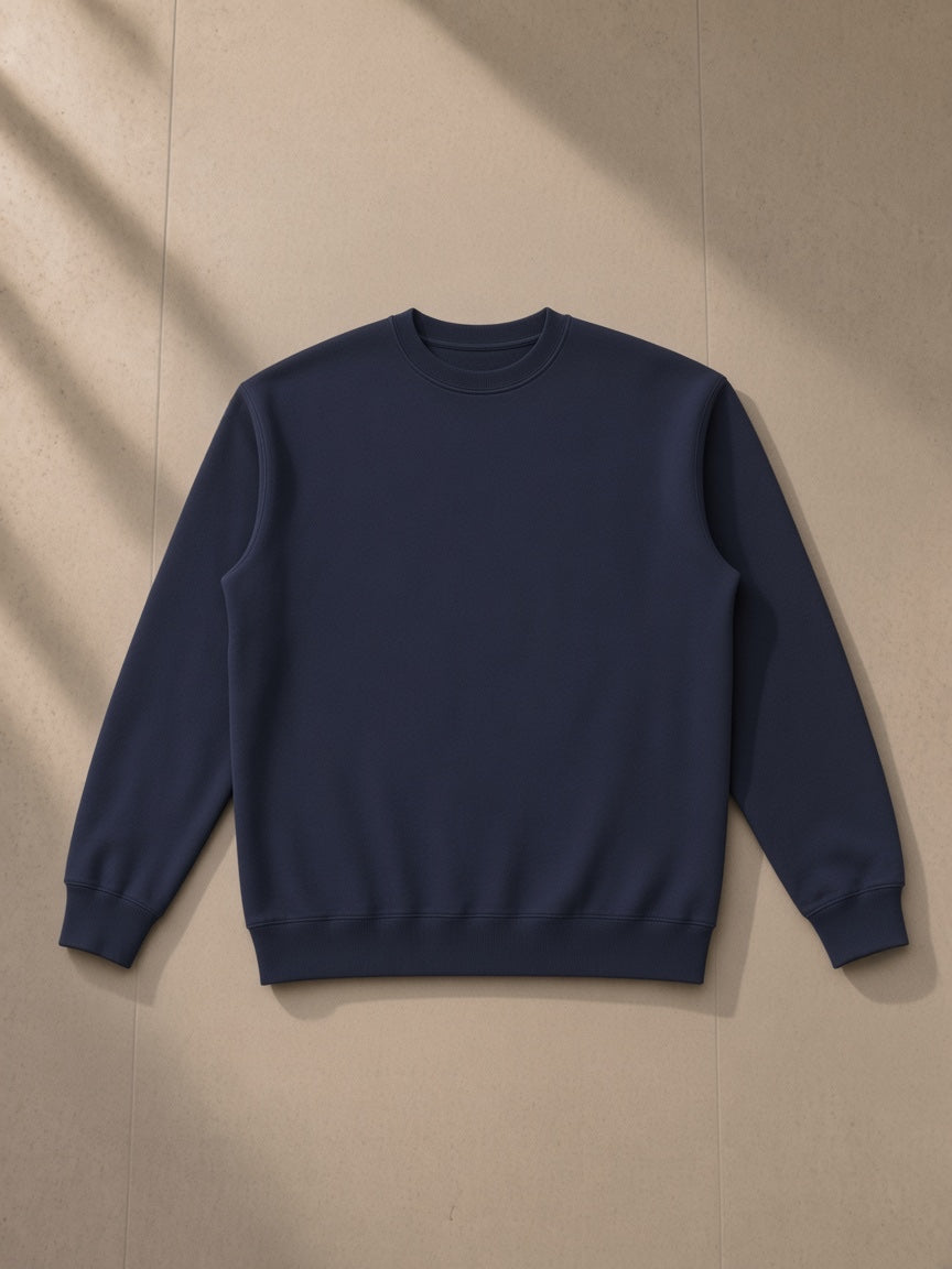 Essential heavyweight crewneck sweatshirt in Navy Blue, laid flat on pale limestone, front view