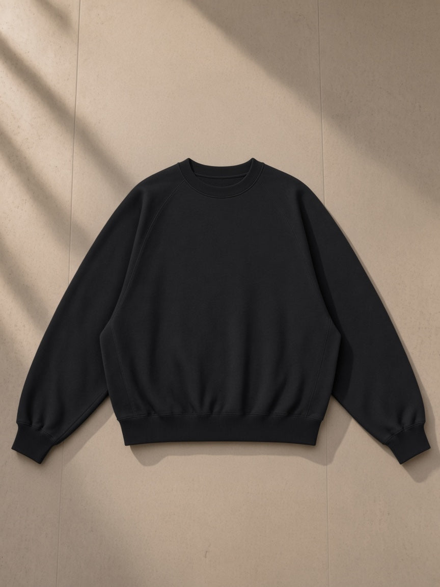 Essential Heavyweight Dolman Sleeve Boxy Sweatshirt in Black, laid flat on pale limestone, front view