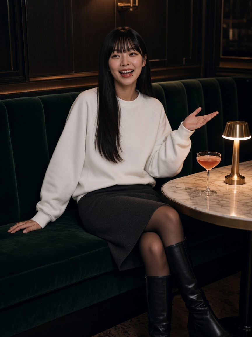 Woman in the Essential Heavyweight Dolman Sleeve Boxy Sweatshirt in White standing in a harbour penthouse in Hong Kong at night