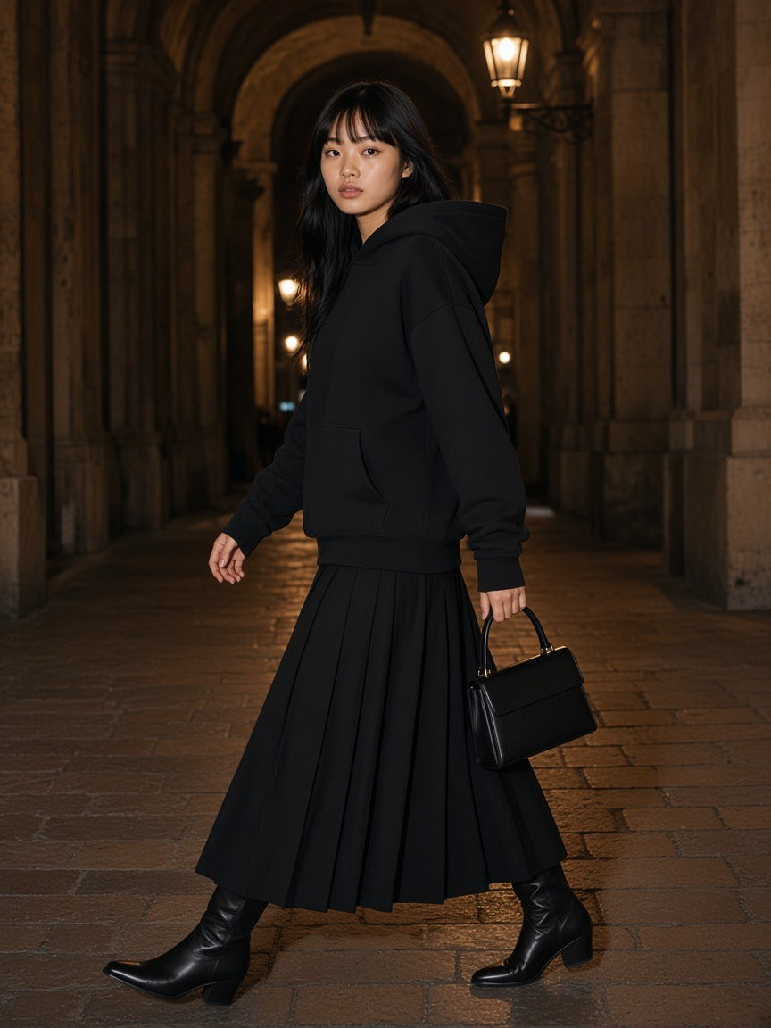 Woman in the Marcel Afters Essential Heavyweight Drop-Shoulder Hoodie in Black in a vaulted stone passage in Lyon at night