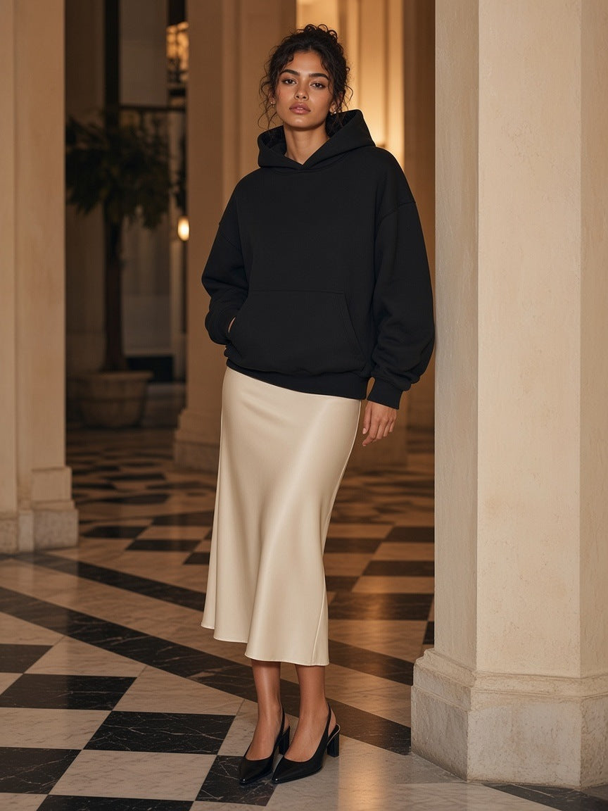 Woman in the Marcel Afters Essential Heavyweight Fleece Hoodie in Black in a colonial hotel colonnade at night in Havana