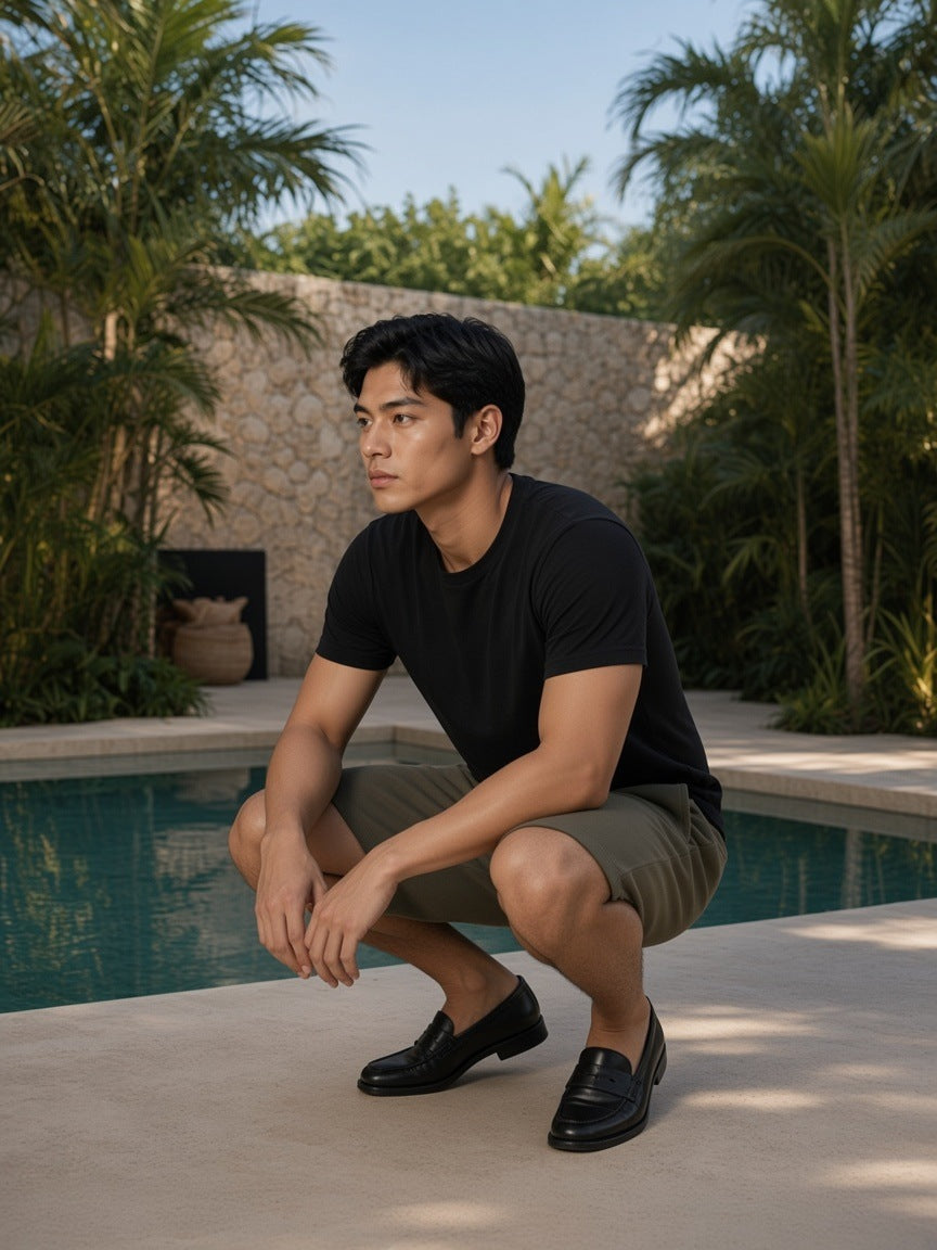 Man in Essential Heavyweight Fleece Shorts in Olive Green by a jungle hotel pool in Tulum by day