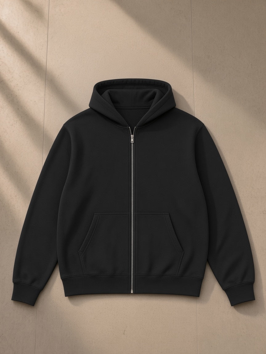 Essential heavyweight high-neck zip-up hoodie in Black, laid flat on pale limestone, front view