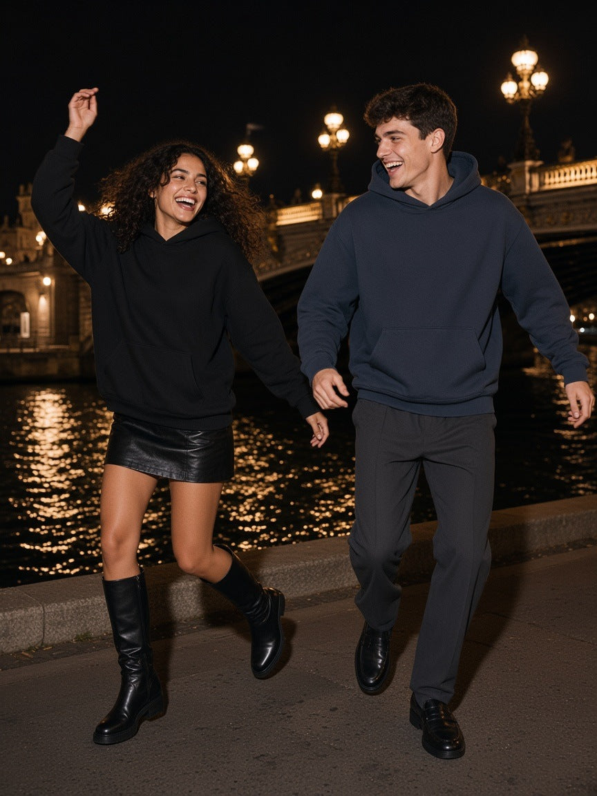 Two people in the Marcel Afters Essential Heavyweight Hoodie, 400 gsm, in Navy Blue and Black dancing on a Seine quay in Paris at night