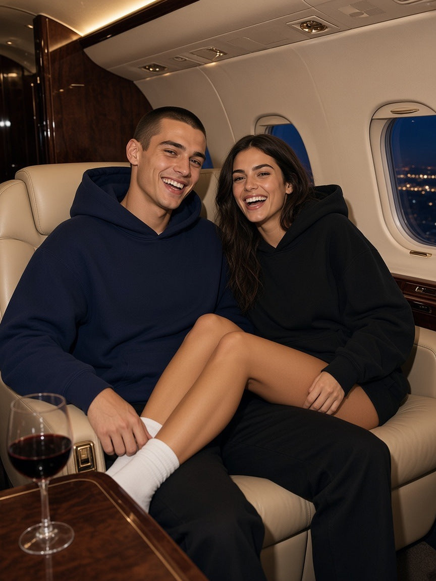 Two people in the Marcel Afters Essential Heavyweight Hoodie in Navy Blue and Black in a private jet cabin at night