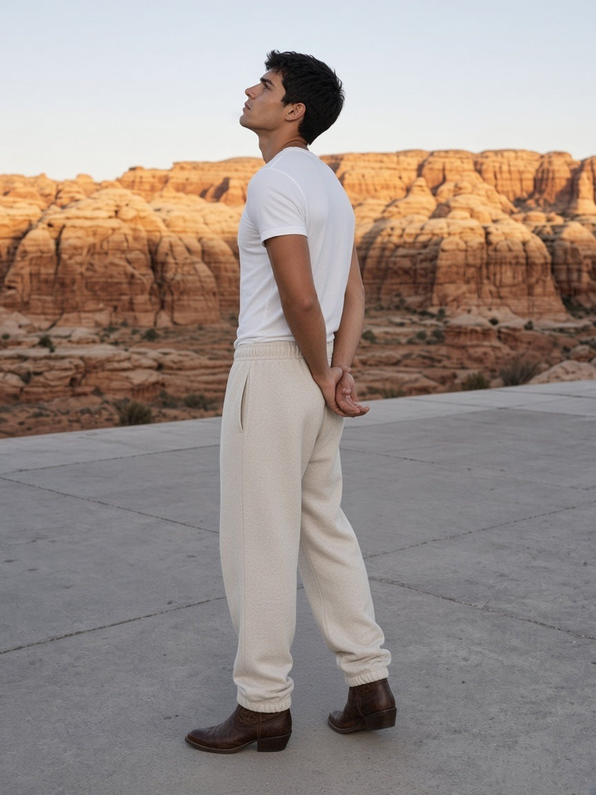 Man in the Essential Jogged Sweatpants in Oat Gray walking a desert resort terrace in Utah by day
