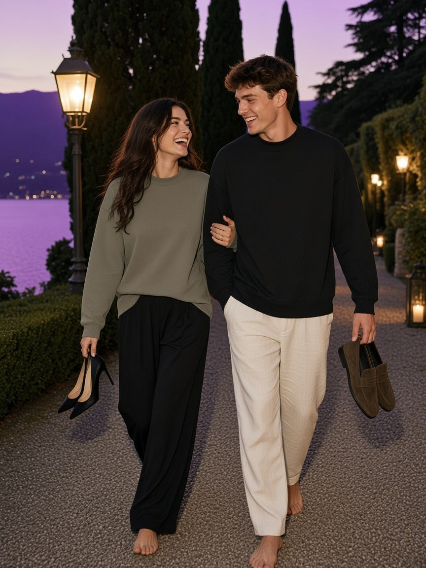 Two people in the Marcel Afters Essential Non-Shrink Mock Neck Sweatshirt in Black and Gray Green in a Lake Como villa garden at dusk