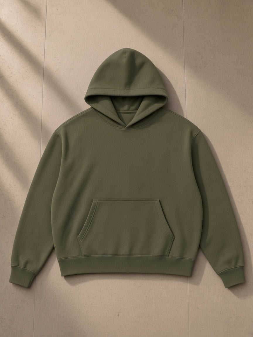 Essential Oversized Hoodie in Army Green, laid flat on pale limestone, front view