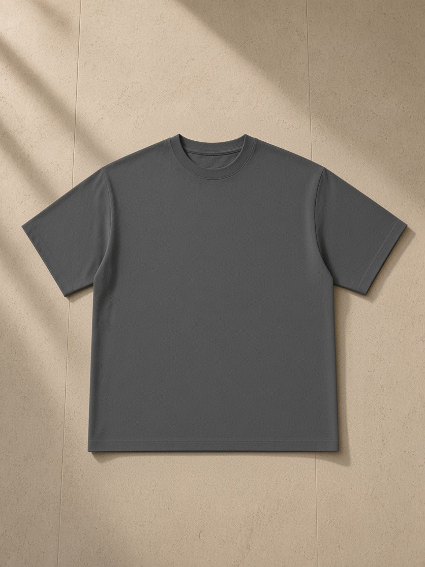Essential Sorona Boxy T-Shirt in Charcoal, laid flat on pale limestone