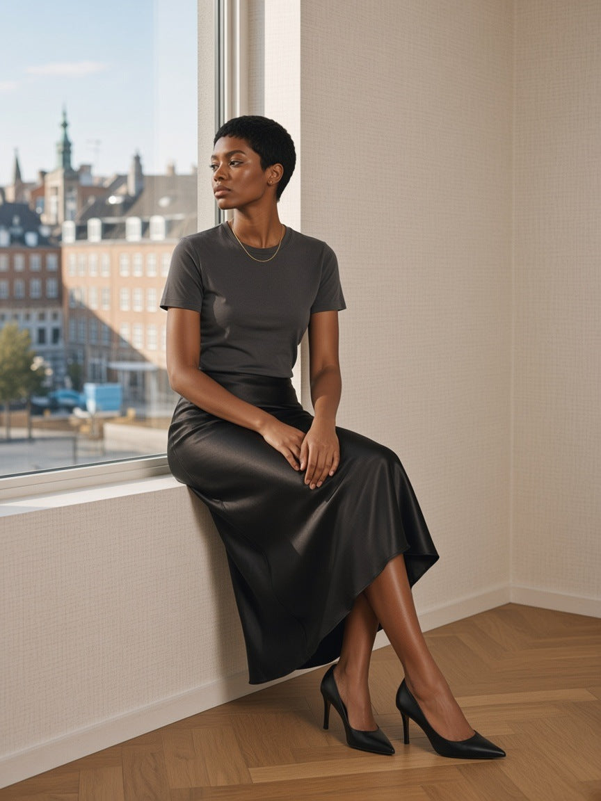 Woman in the Essential Standard Shoulder T-Shirt in Dark Gray in a pale-oak hotel suite in Copenhagen in the morning