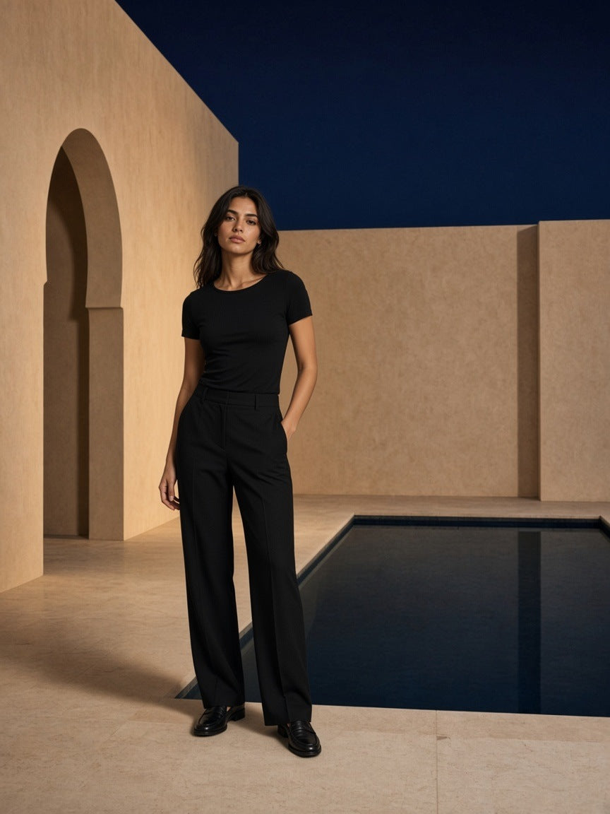 Woman in the Essential Wide Neck Baby T-shirt in Black by the pool in a riad courtyard in Marrakech at night