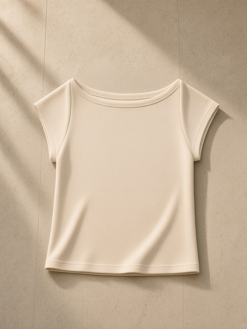 Essential Wide Neck Baby T-shirt in Light Apricot, laid flat on pale limestone