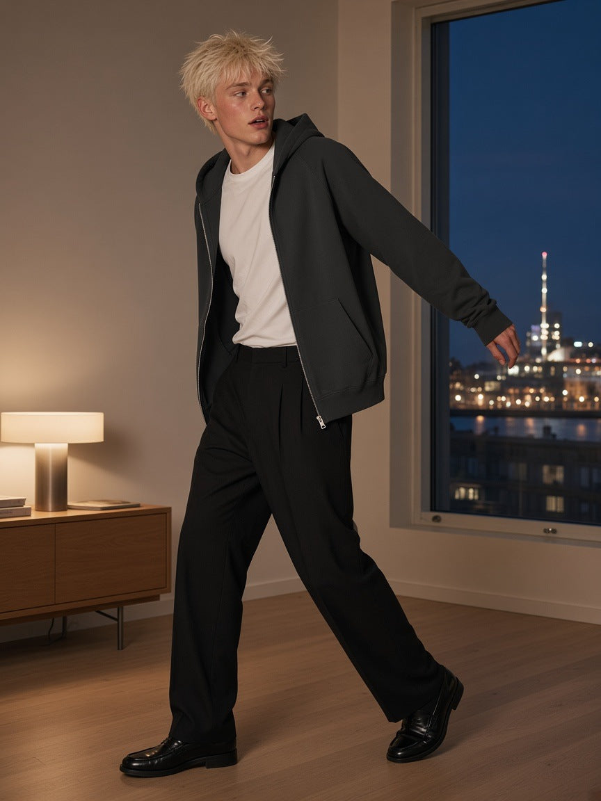Man in the Marcel Afters Essential Zip-up Fleece Hoodie in Carbon Gray in a hotel room in Copenhagen at night
