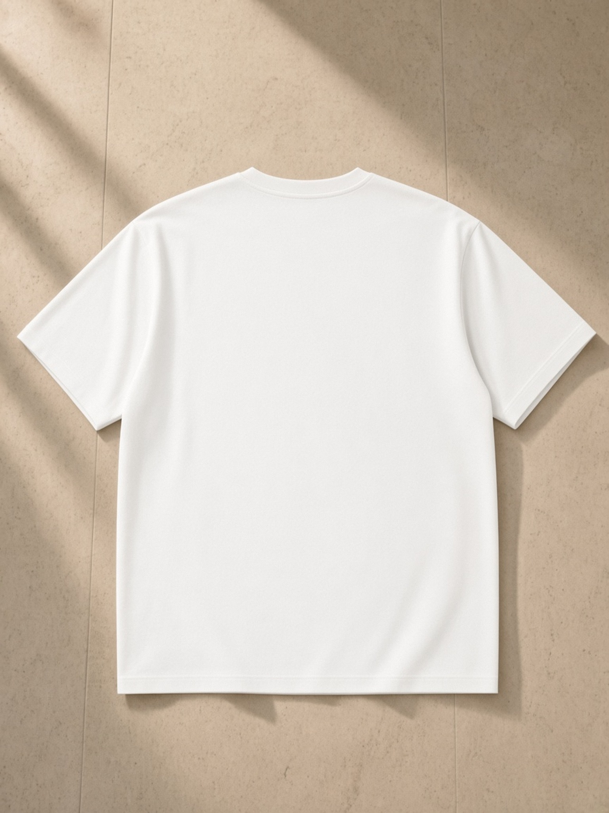 Sorona Quick-Dry Boxy T-Shirt in White, laid flat on pale limestone, back.